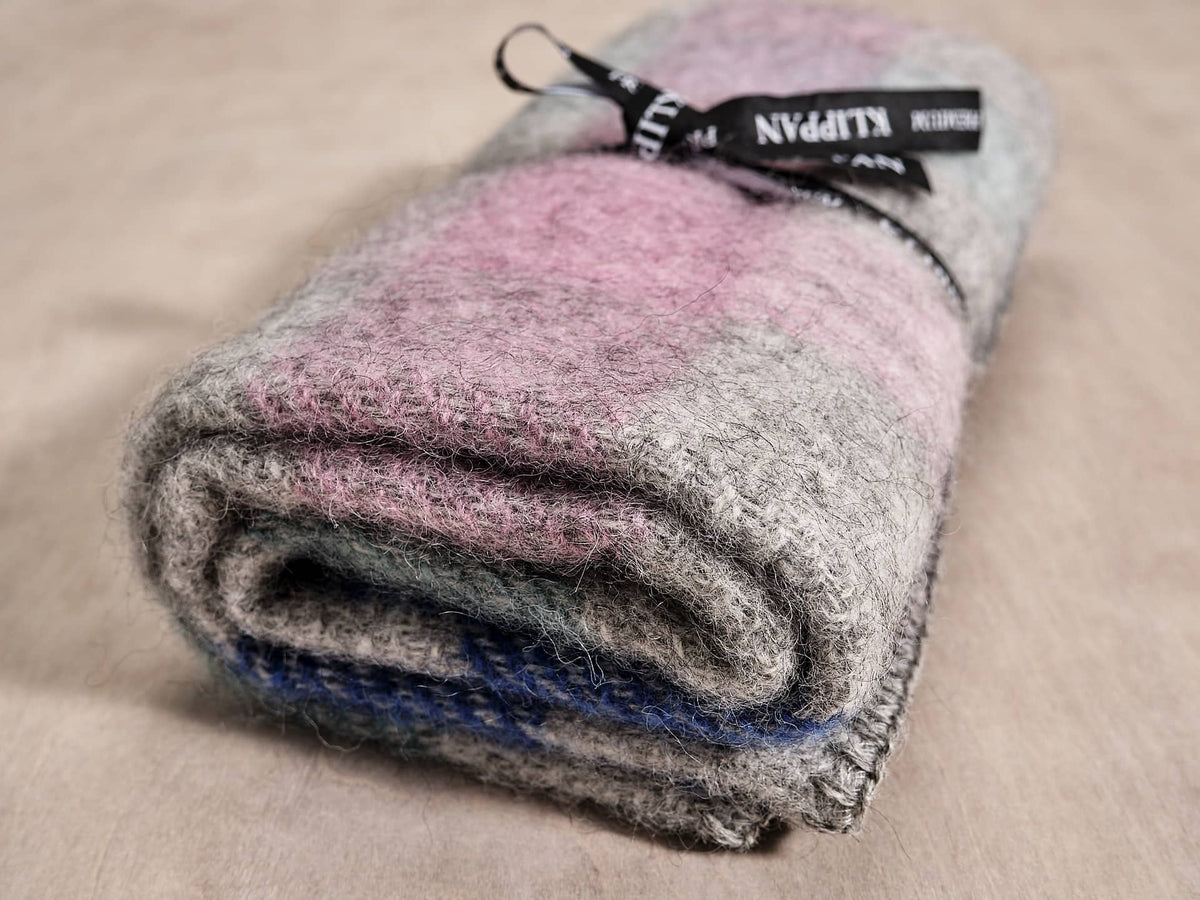 A Klippan Gotland Wool Baby Throw - Multi Pastel blanket with a label on it.