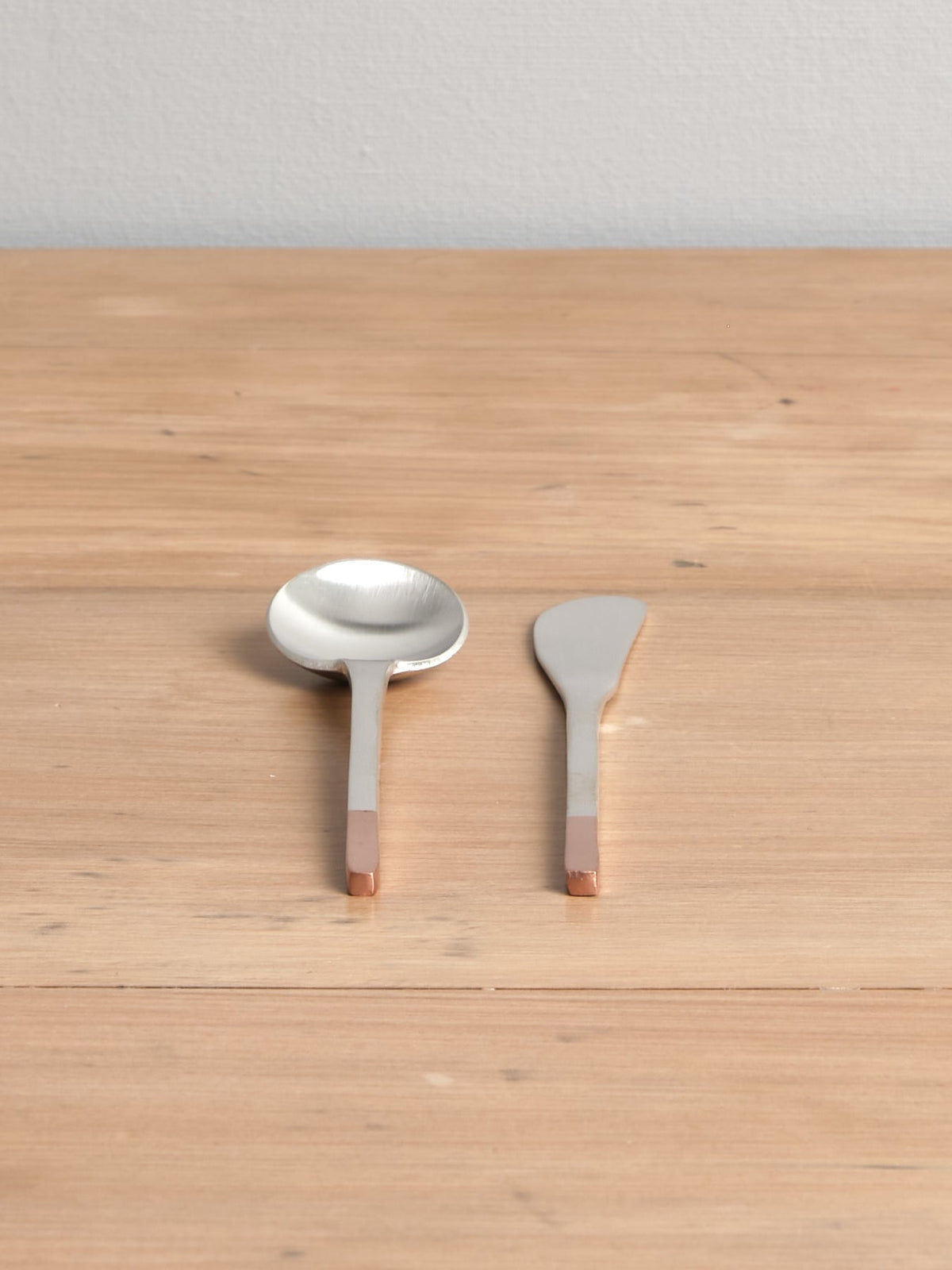 Two Copper and Stainless Steel Teaspoons on a wooden table. (Brand: Kobo Aizawa)