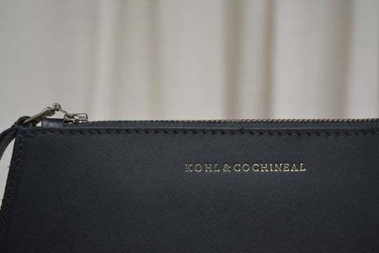 A Maya Clutch – Moss by Kohl &amp; Co, with a gold zipper.