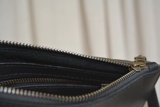 A close up of a Maya Clutch – Moss by Kohl &amp; Co with a zipper.