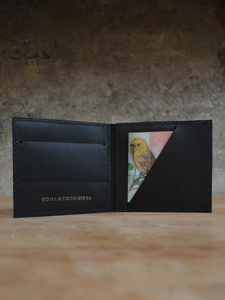 A black leather wallet with a picture of a bird on it, called The Skinny Wallet by Kohl &amp; Co.