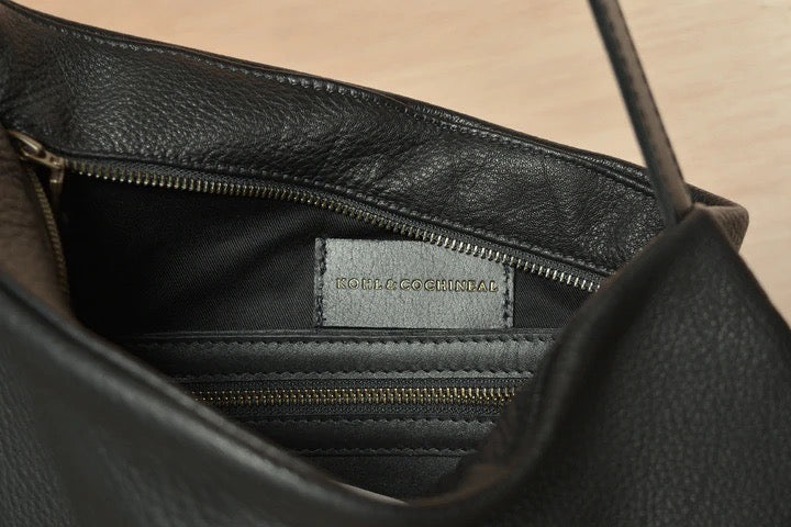 The inside of a Side Saddle black leather bag with a zipper. (Brand Name: Kohl &amp; Co)