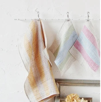 Three Kontex Linen Tea Towels – Yellow or Navy hanging on a wall.