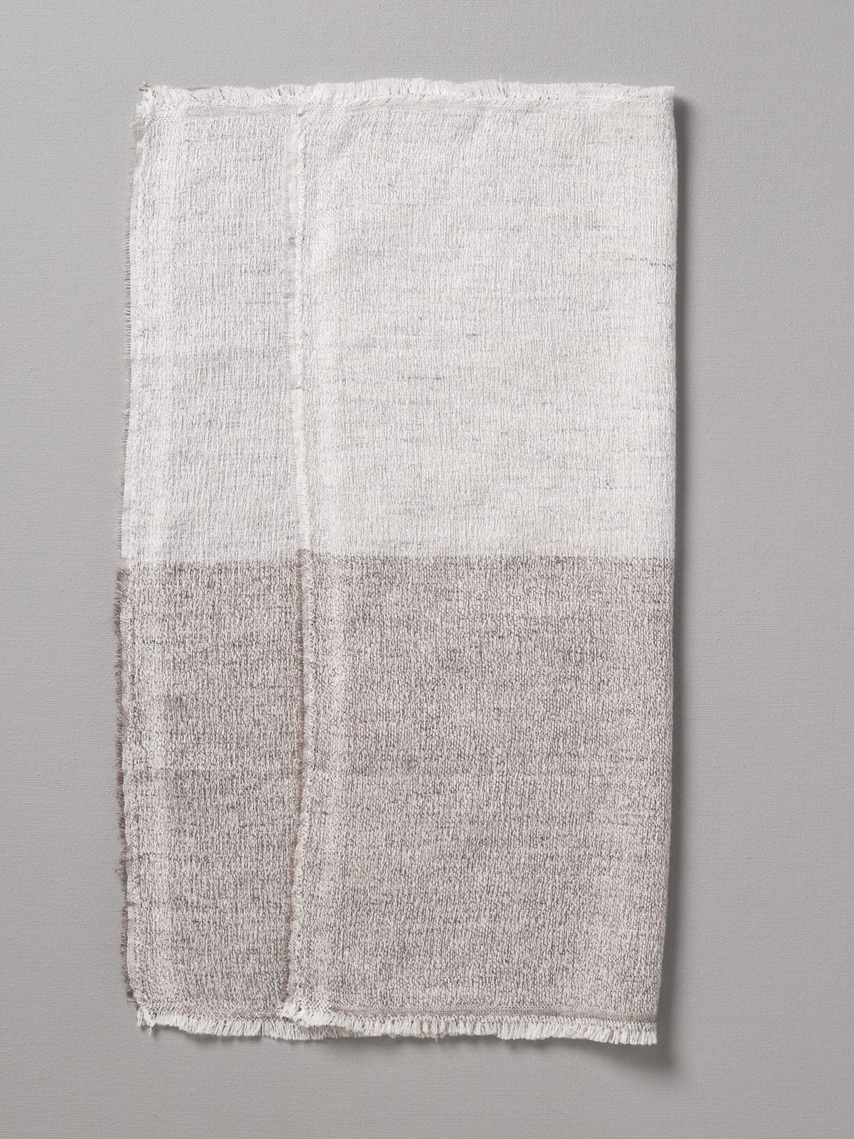 Two-toned linen Kontex Shukin Towel with frayed edges displayed on a grey background, made in Imabari.