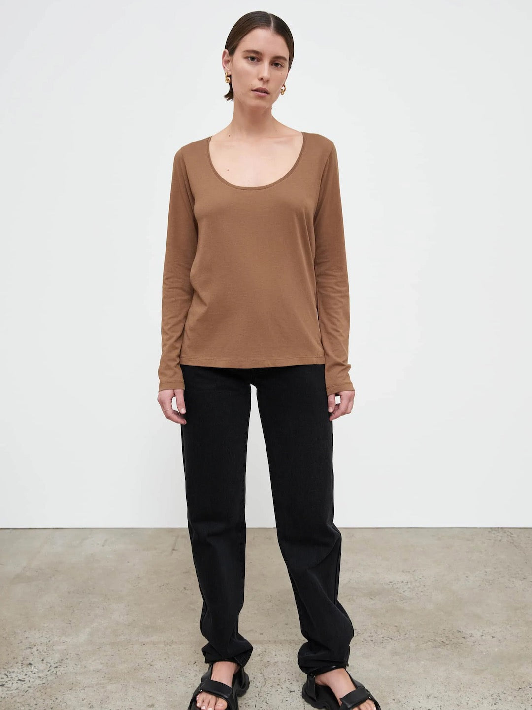 The model is wearing a Ballet Top - Earth by Kowtow and black pants.