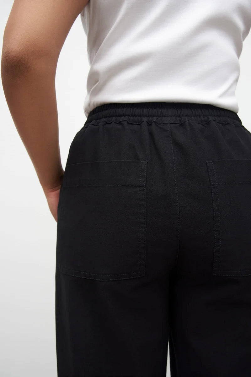 The back view of a woman wearing Kowtow&#39;s Blake Pants – Black.