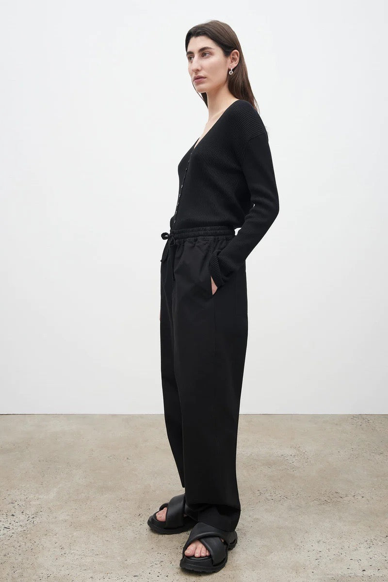 The model is wearing Kowtow&#39;s Blake Pants – Black and sandals.