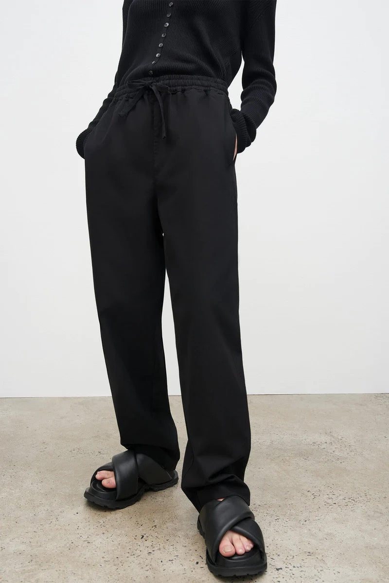 The model is wearing black Blake Pants – Black from Kowtow and a black sweater.