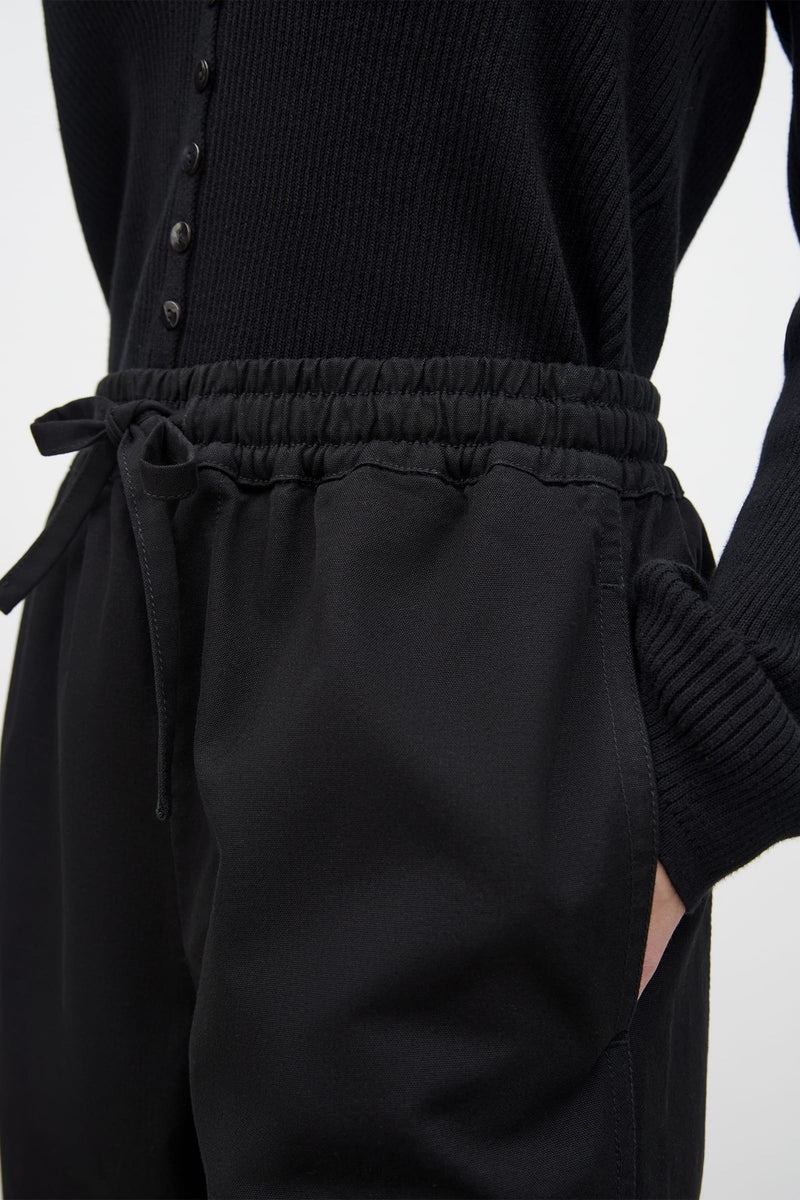 A woman wearing Kowtow&#39;s Blake Pants – Black and a black sweater.