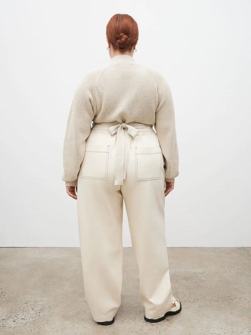 The back view of a woman wearing Kowtow&#39;s Blake Pants – Greige and a cream sweater.