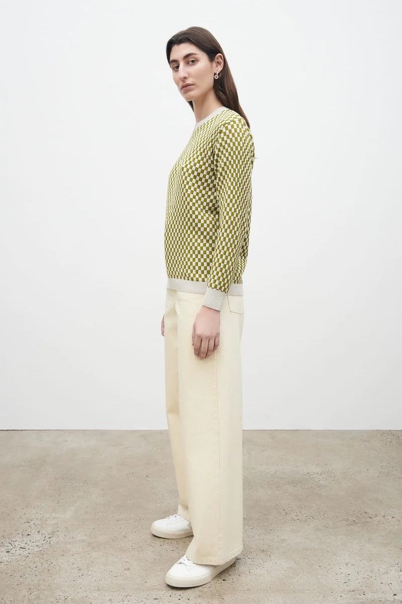 A model wearing the Kowtow Checkerboard Knit Crew – Lawn Check sweater and wide leg pants.