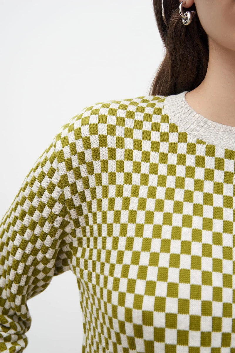 A woman wearing a Kowtow Checkerboard Knit Crew – Lawn Check sweater.
