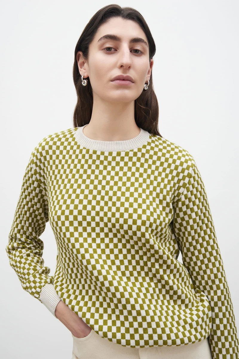 A woman wearing a Kowtow Checkerboard Knit Crew - Lawn Check sweater.