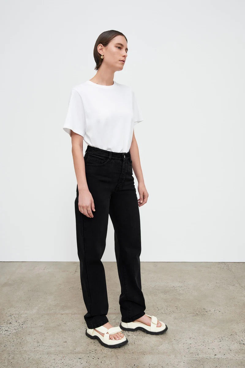 A woman wearing Kowtow&#39;s Classic Jeans - Black Denim and a white t-shirt.