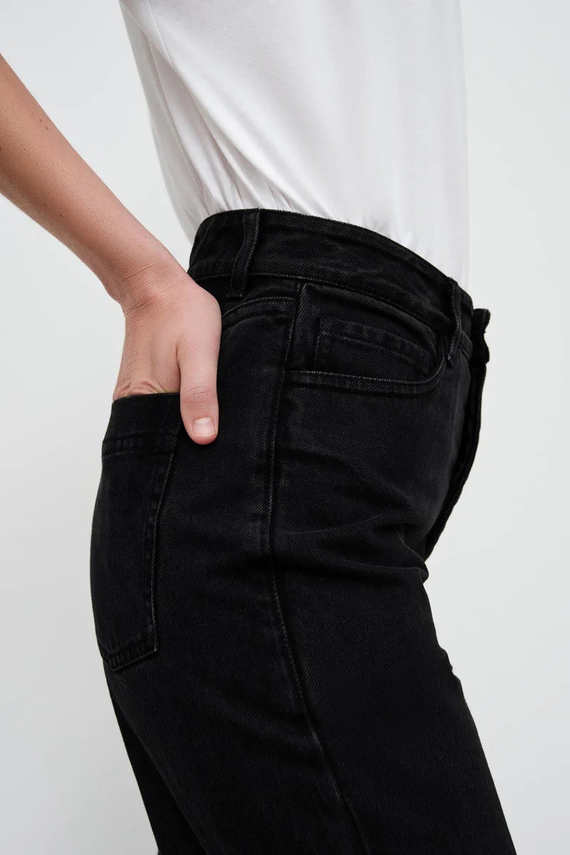 A woman wearing Kowtow&#39;s Classic Jeans - Black Denim with a white t-shirt.