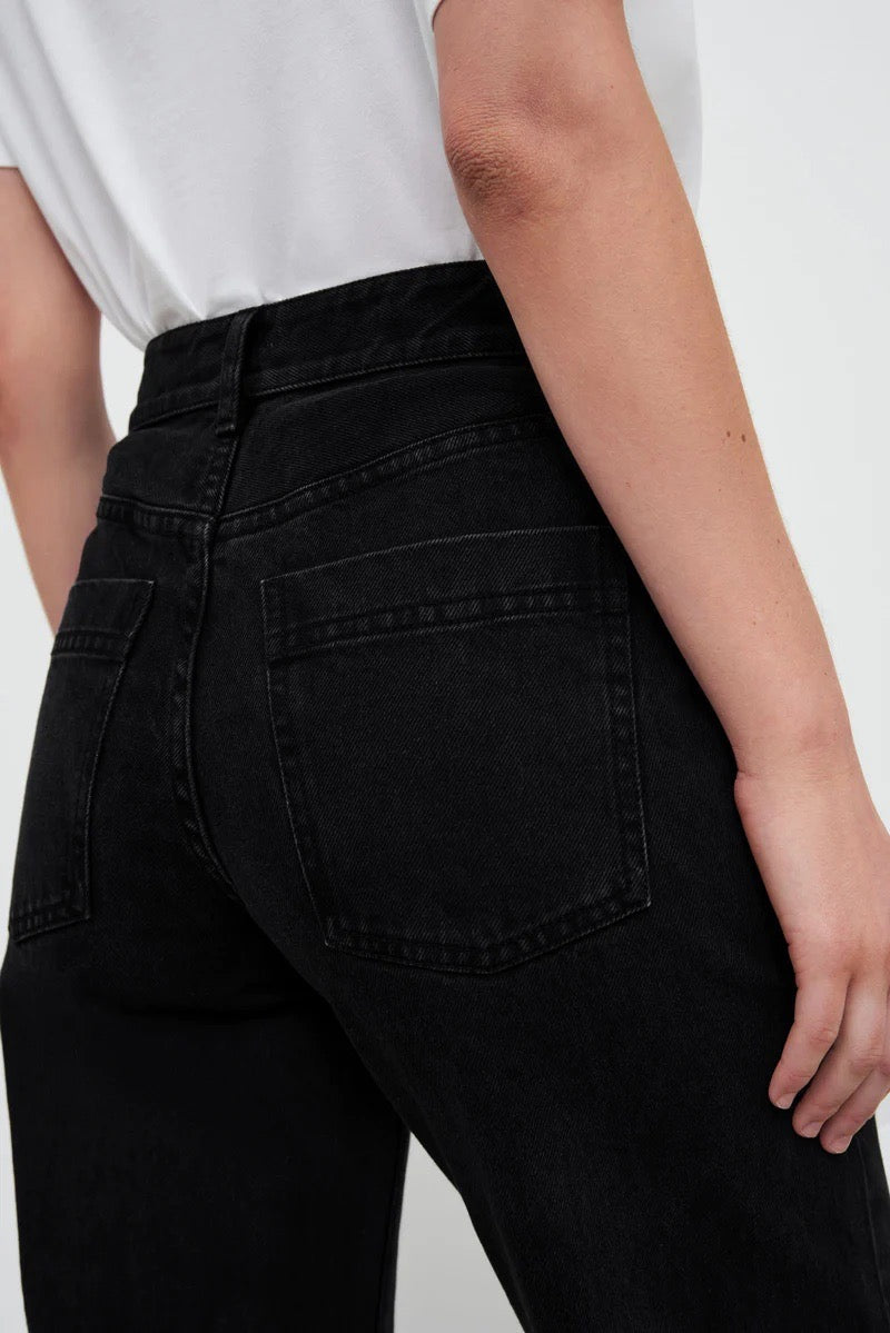 The back view of a woman wearing Classic Jeans – Black Denim by Kowtow.