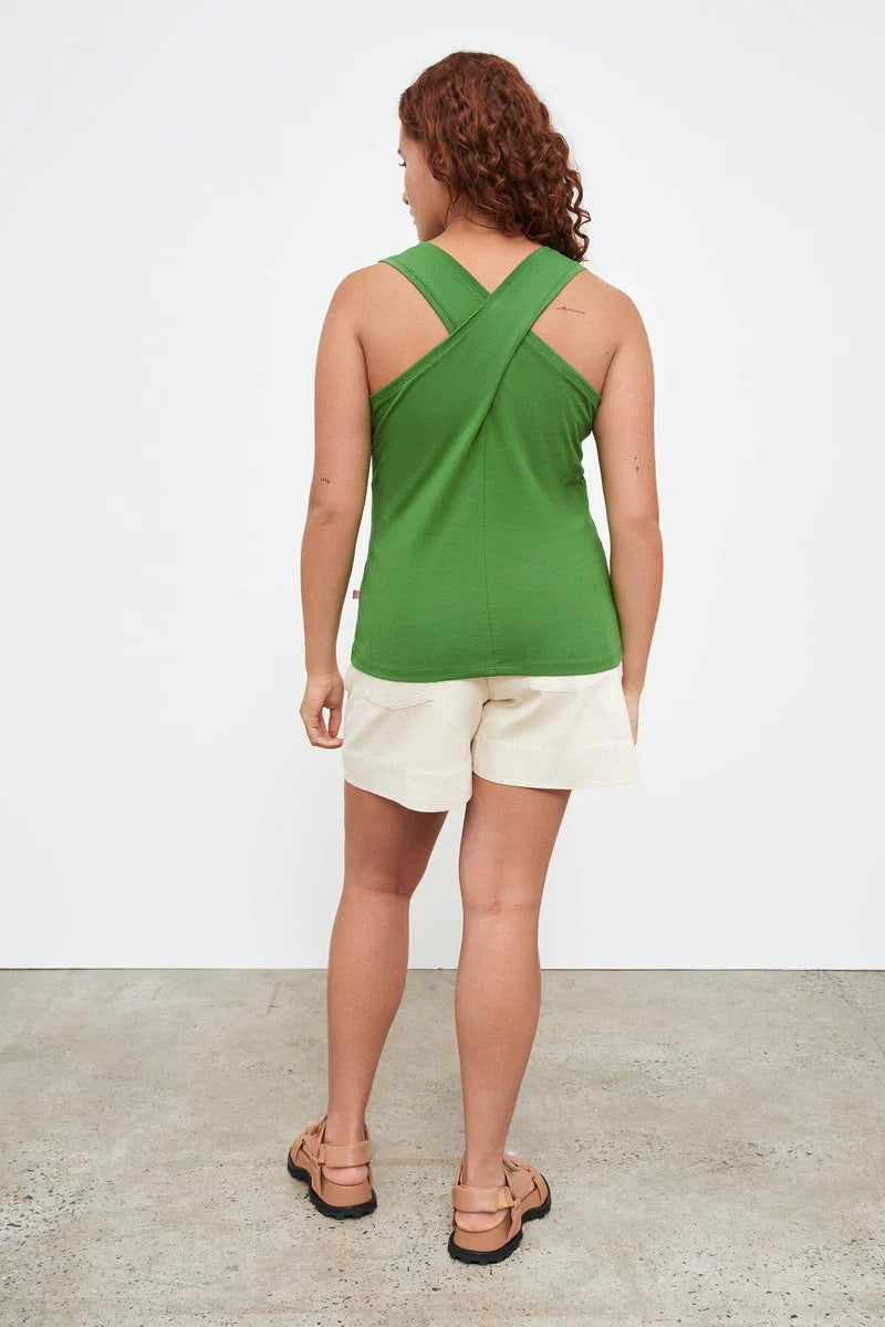 The back view of a woman wearing a Kowtow Cross Back Singlet - Bright Green.