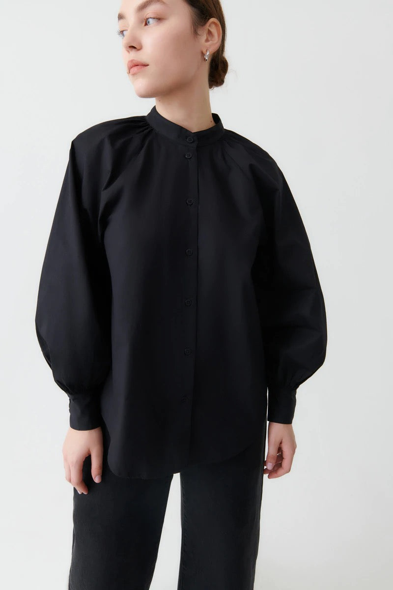 The model is wearing a Kowtow Ella Shirt - Black with puff sleeves.