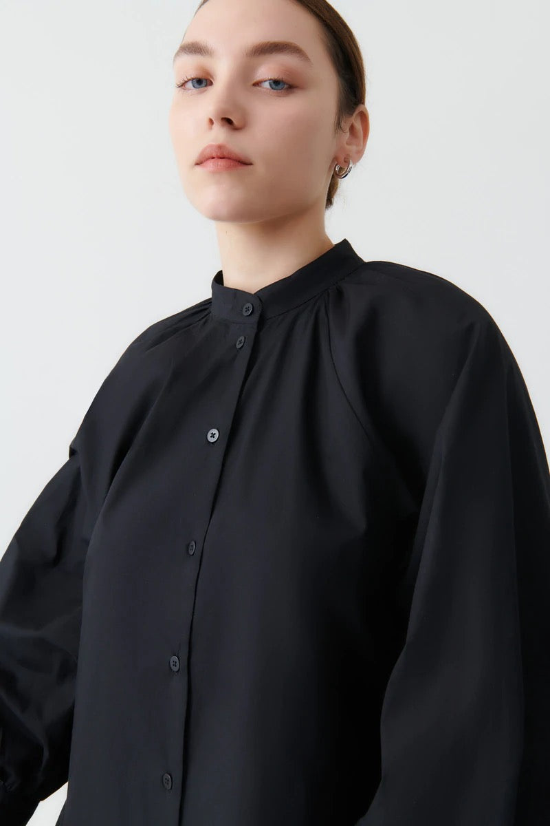 The model is wearing a Kowtow Ella Shirt - Black with long sleeves.