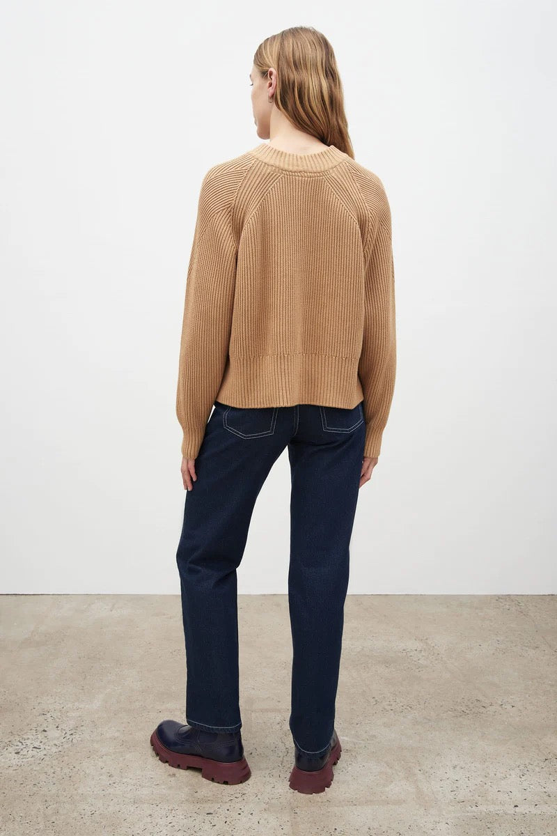 The back view of a woman wearing a Kowtow Henri Crew - Beige sweater and jeans.