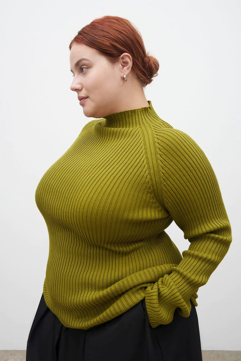 A woman wearing a Kowtow Row Top - Lawn turtleneck sweater.