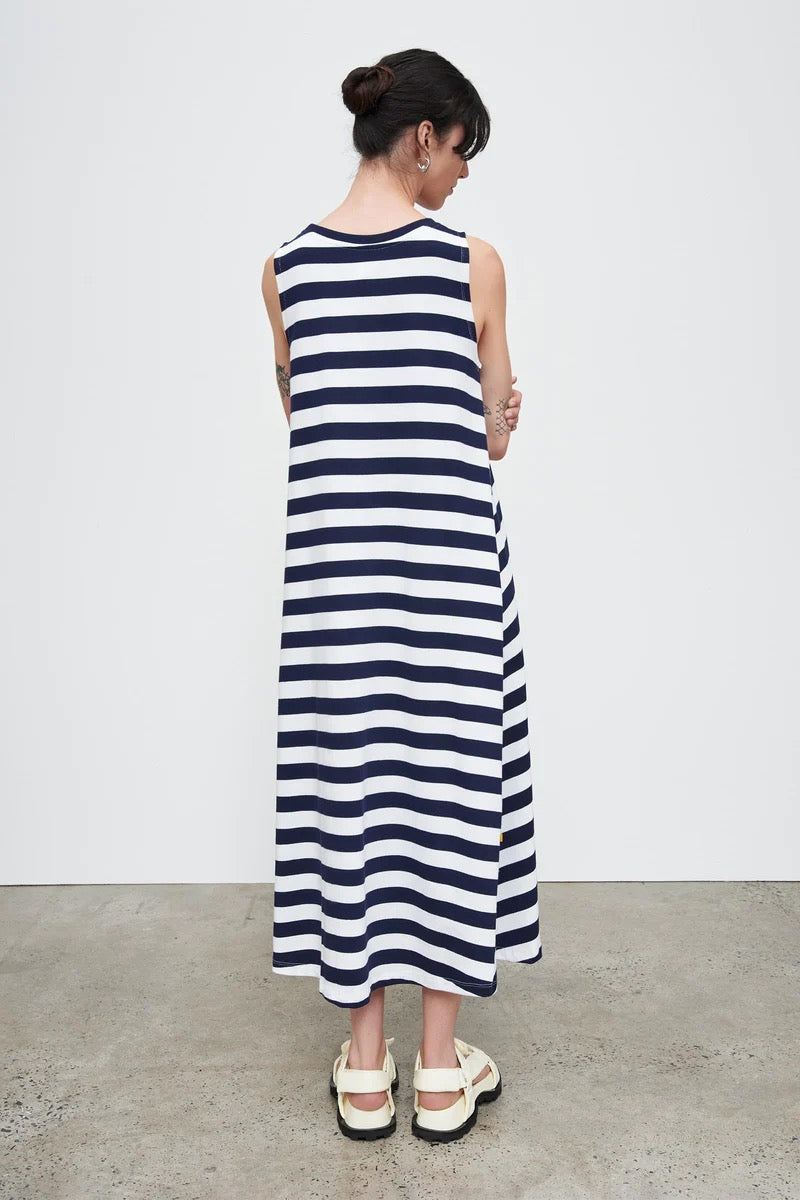 The back view of a woman wearing a Kowtow Rugby Tank Swing Dress – Navy White Stripe.