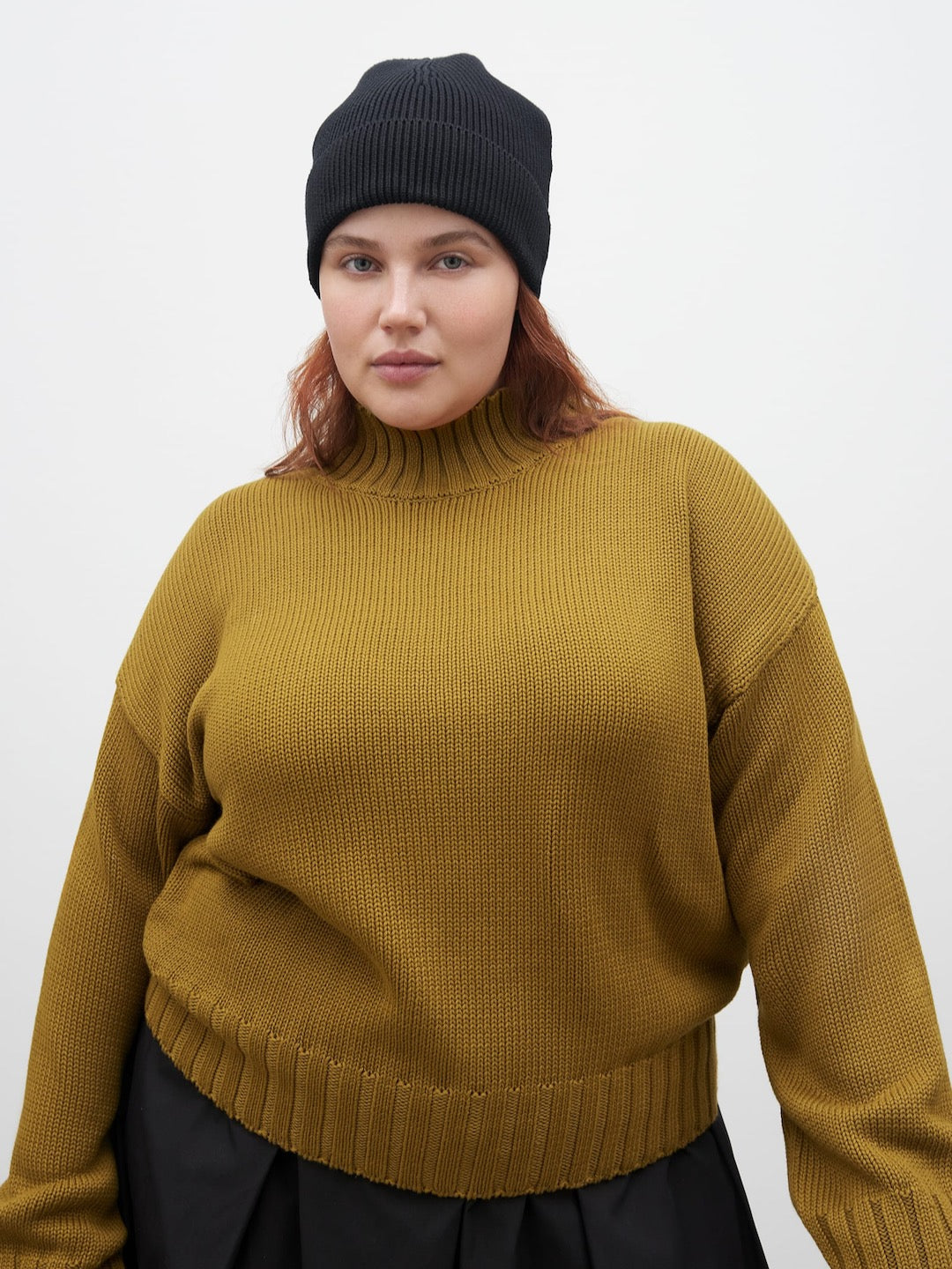A model wearing a Staple Sweater – Chartreuse by Kowtow and black beanie.
