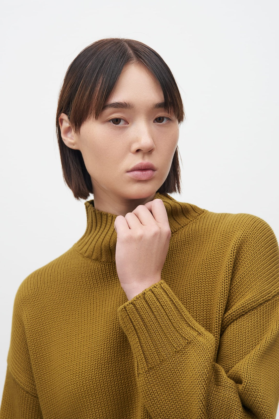 The model is wearing a Kowtow Staple Sweater - Chartreuse.