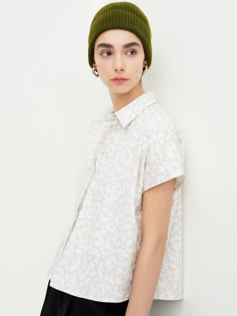 The model is wearing a Studio Shirt - Flora Print by Kowtow with a green beanie.