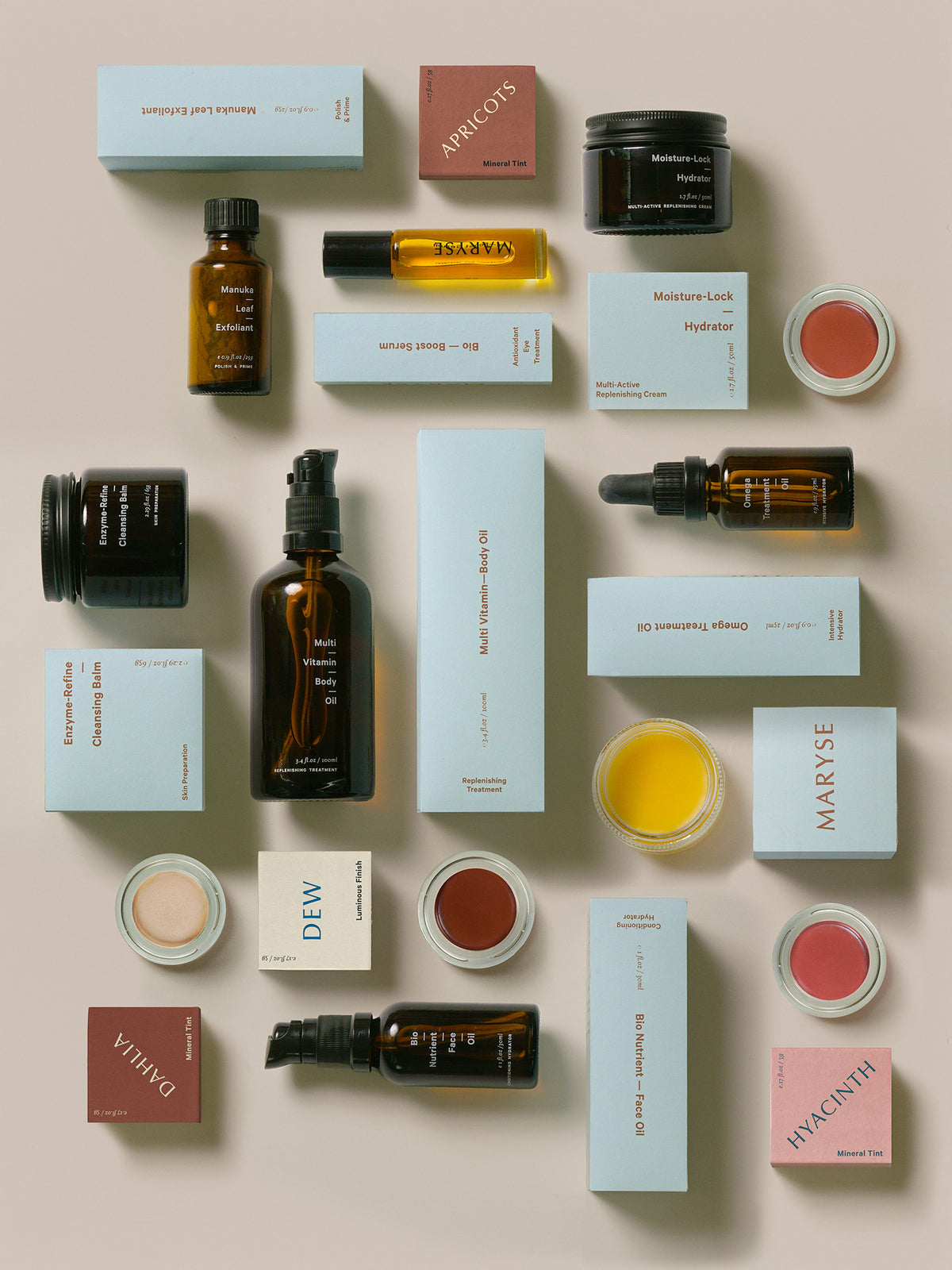 A collection of MARYSE Omega – Treatment Oil cosmetics arranged on a white surface.