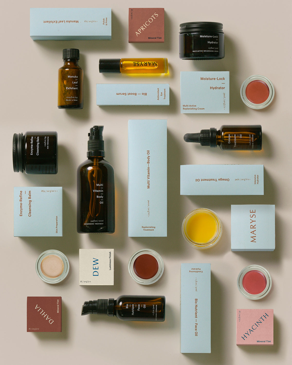 A collection of MARYSE Omega – Treatment Oil cosmetics arranged on a white surface.