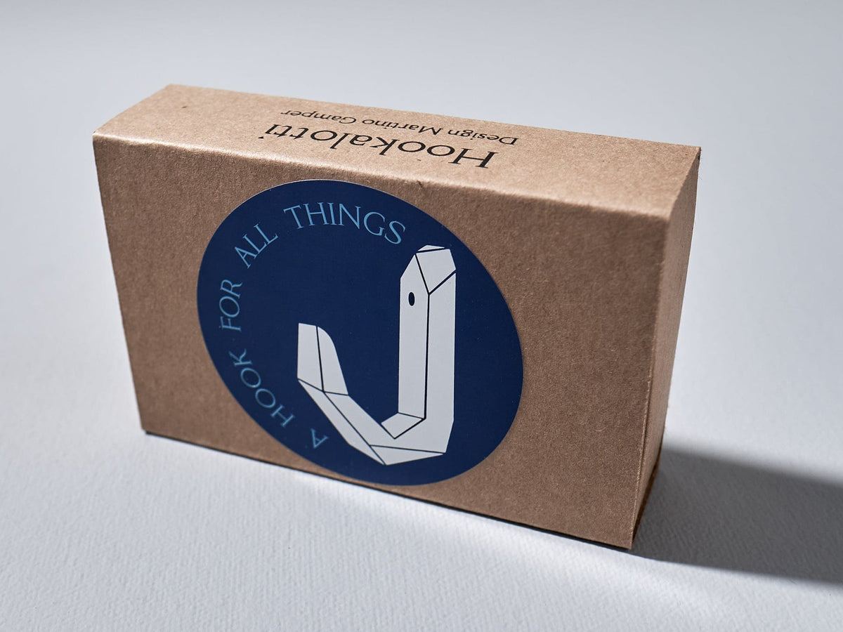 A Hookalotti cardboard box with a blue sticker on it from the brand Martino Gamper.