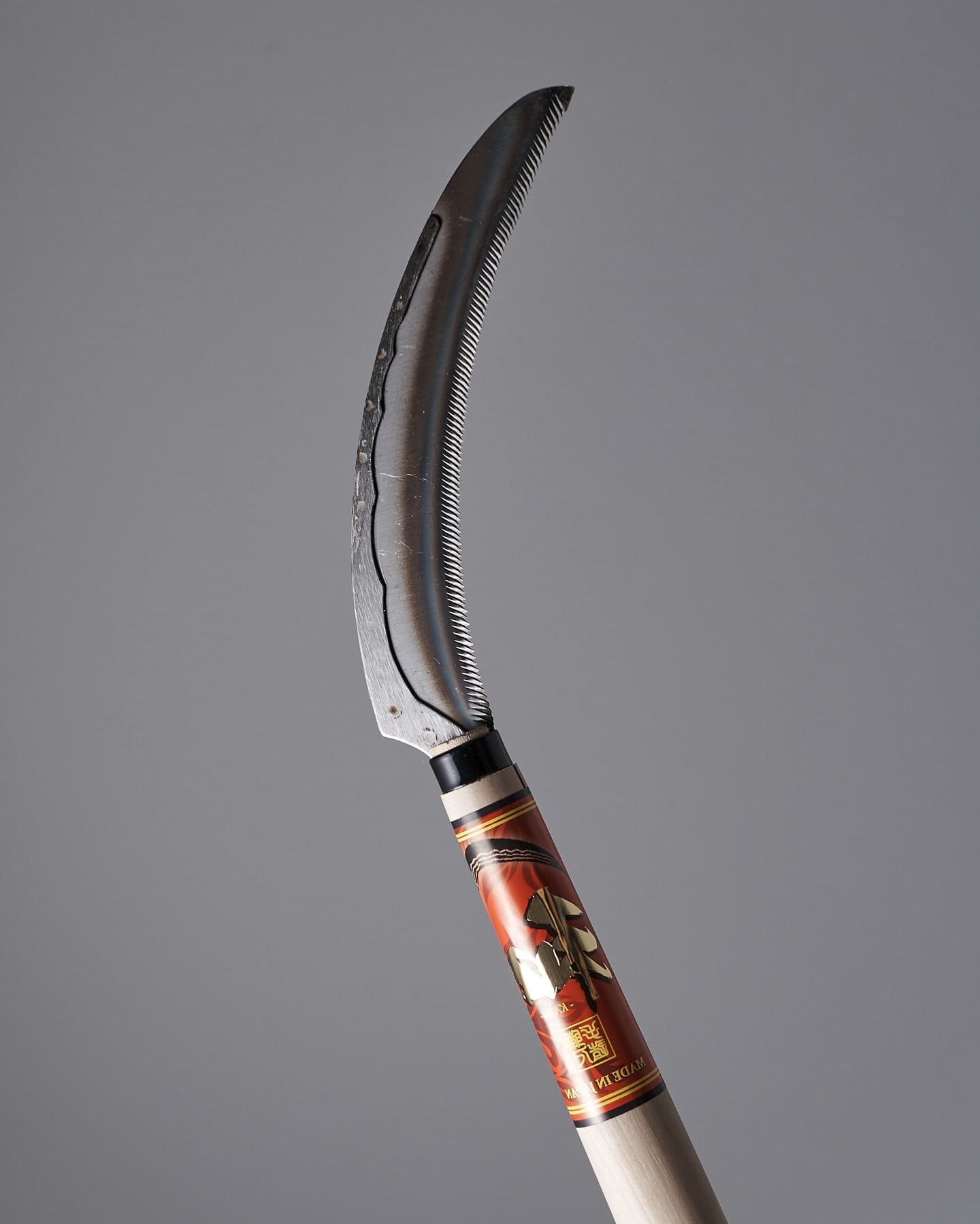 A Flax Cutter with a wooden handle on a gray background. (Maruyoshi)