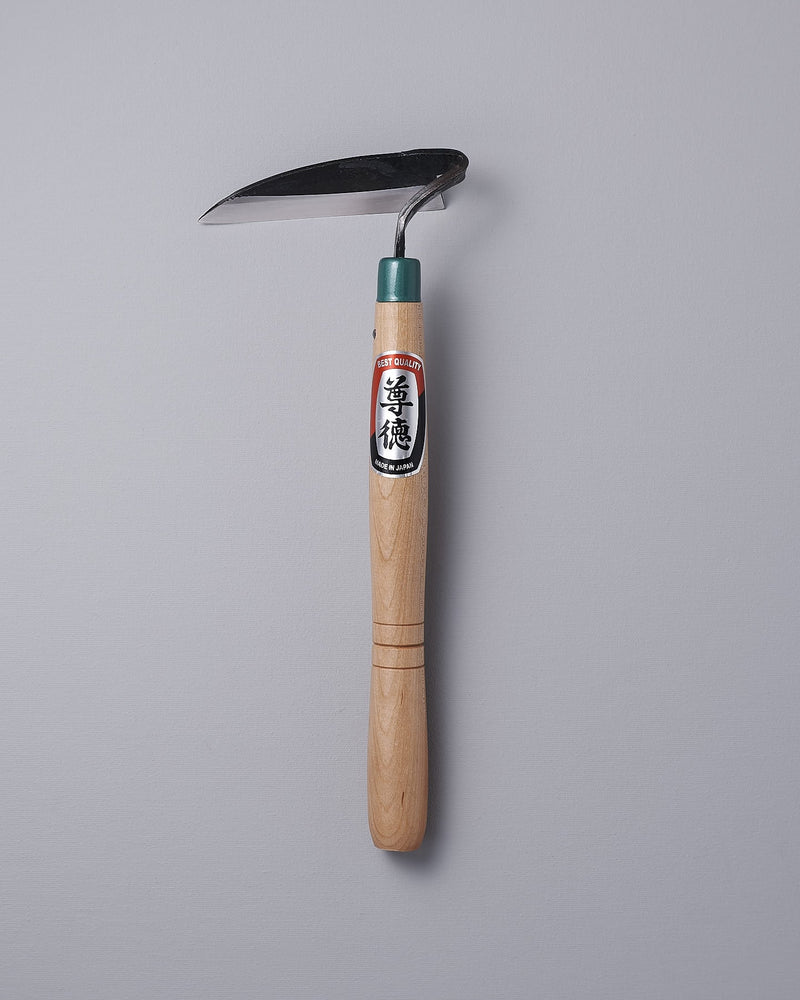 A Maruyoshi garden hoe with a green handle on a gray background.
