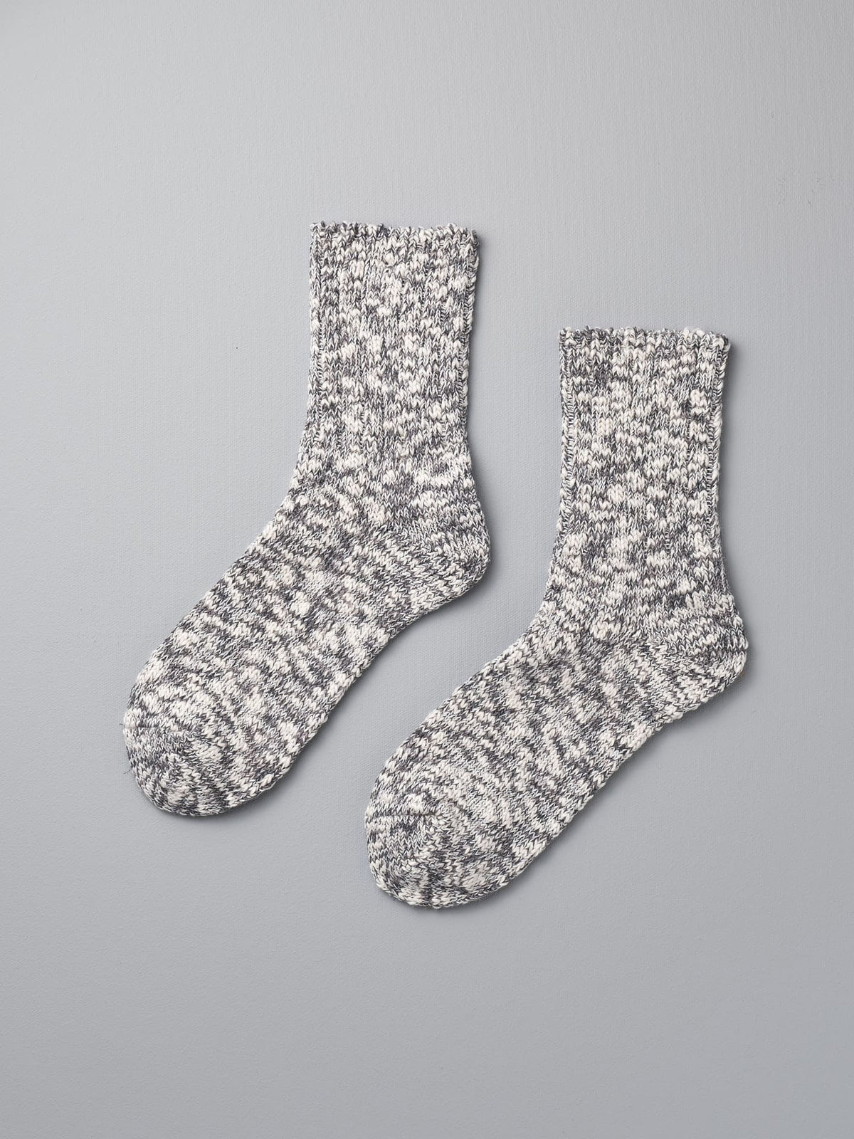 A pair of Mauna Kea Japanese Slub Socks – Grey on a grey background.