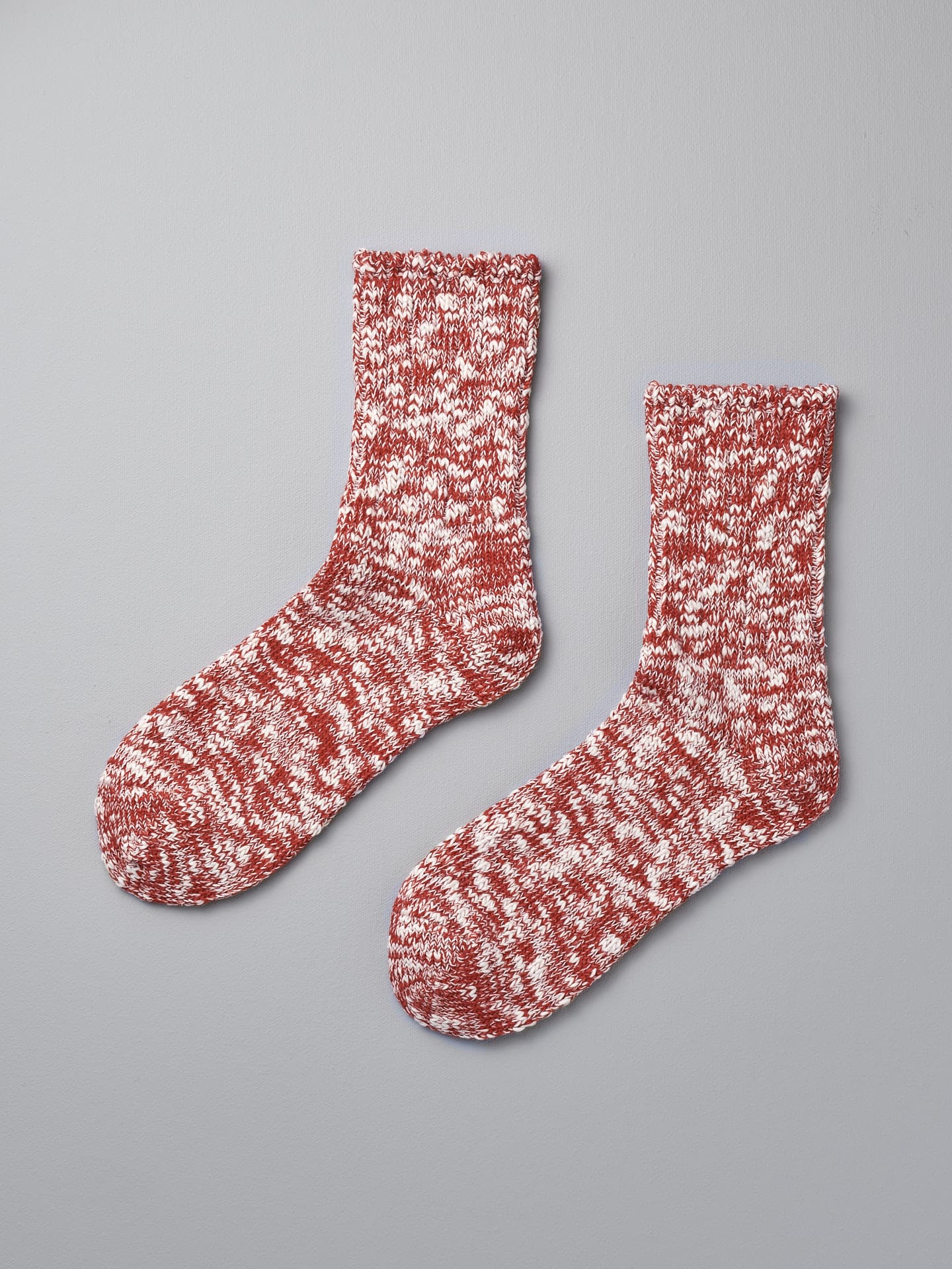 A pair of Mauna Kea Japanese Slub Socks - Red on a grey background.