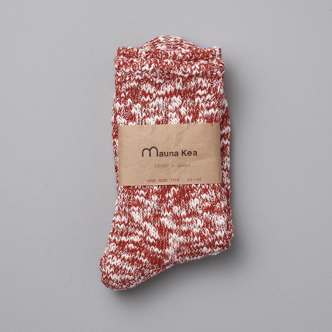 A pair of Japanese Slub Socks – Red by Mauna Kea on a grey background.