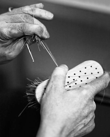 Black and white photo of a person working on an Iris Hantverk Vegetable Brush.