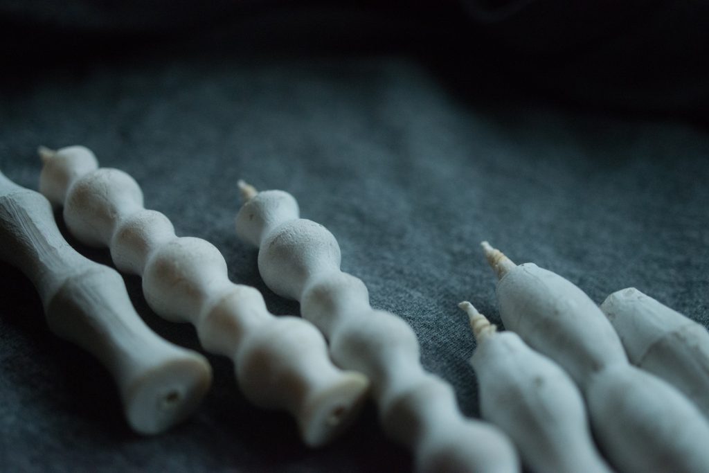 A group of NANAO-P candle sticks by Takazawa laying on a dark surface.