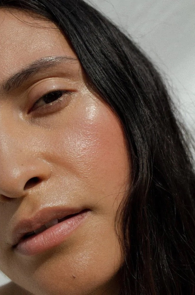 A close up of a woman with long black hair wearing NOTO&#39;s Mini Deep Serum.