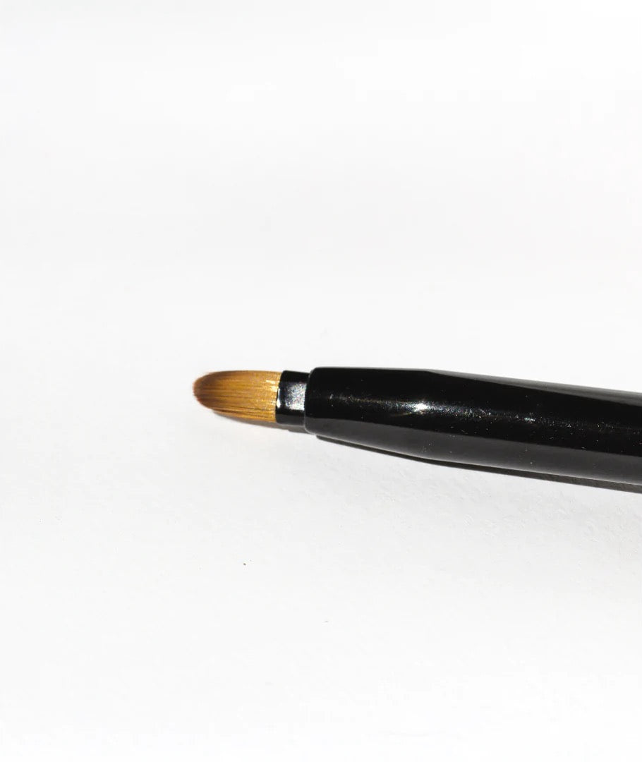 A NOTO Lip + Cheek Duo Brush on a white surface.
