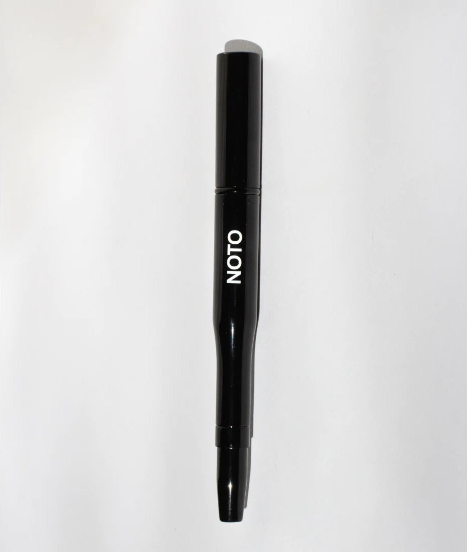 A black Lip + Cheek Duo Brush with the brand name NOTO on it.
