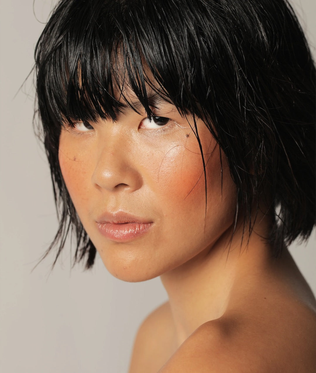 A young asian woman with a wet face was using the Ono Ono - Multi-Bene Stain Stick // Lips + Cheeks by NOTO.