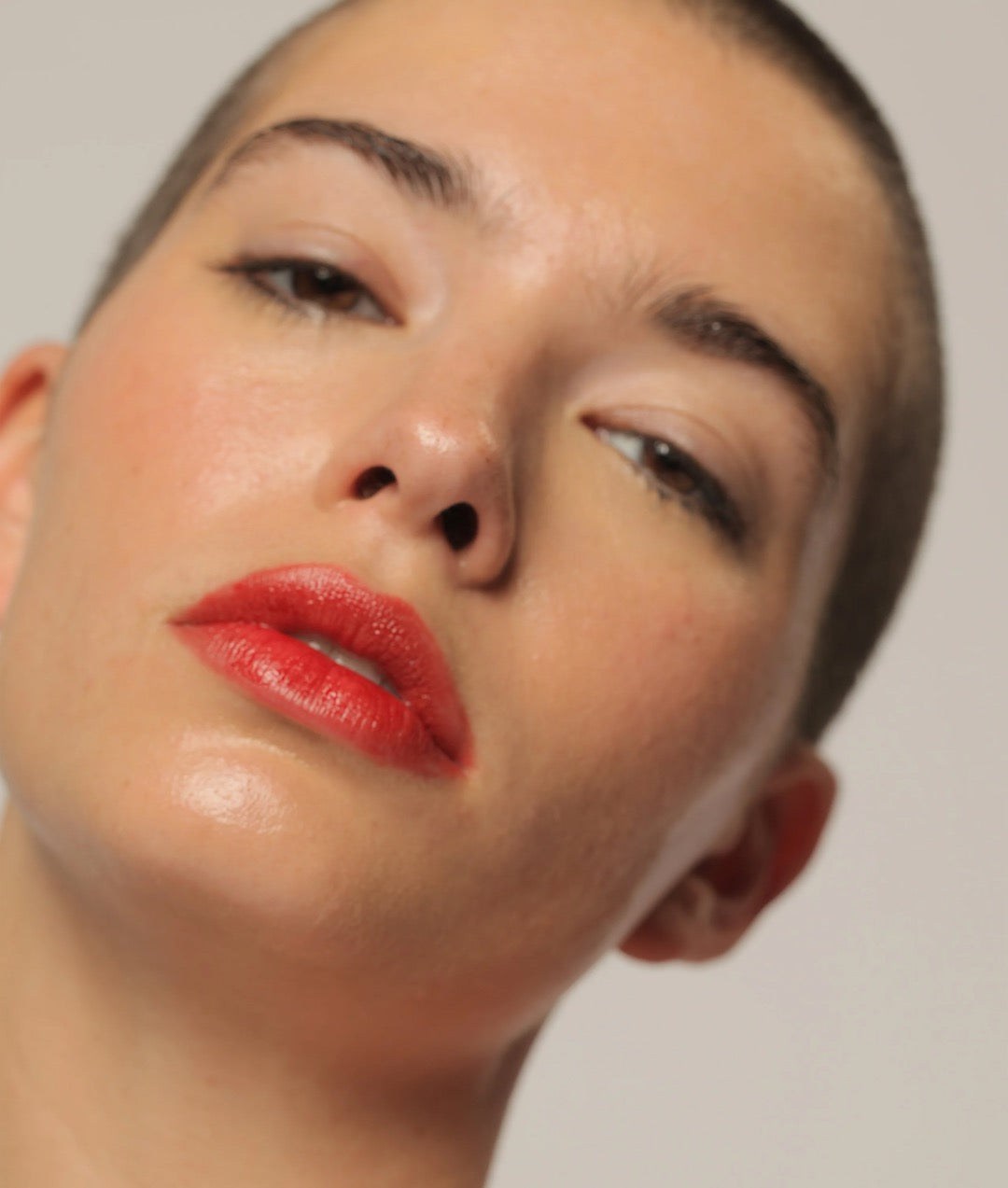A woman with a shaved head and red lipstick was wearing NOTO&#39;s Oscillate – Multi-Bene Stain Stick on her lips + cheeks.