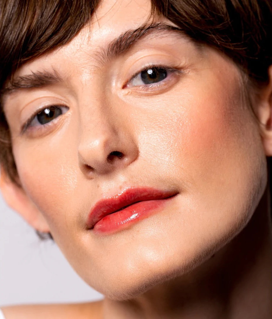 A woman with short hair and red lipstick is wearing NOTO&#39;s Oscillate – Multi-Bene Stain Stick // Lips + Cheeks.