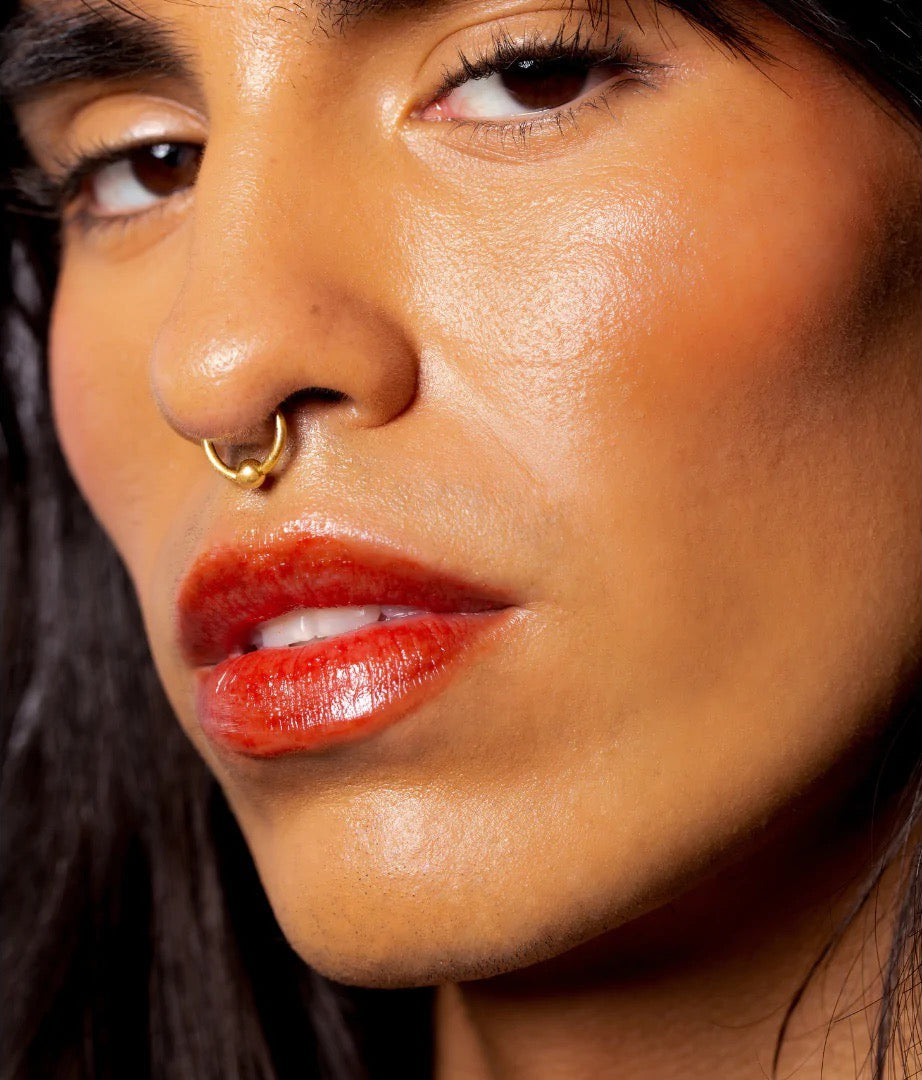 A close up of a woman with a NOTO Oscillate – Multi-Bene Stain Stick // Lips + Cheeks.
