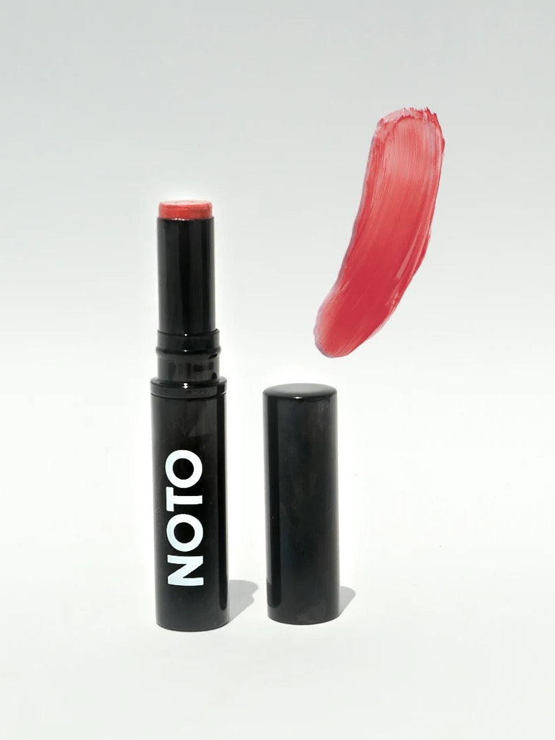 A NOTO lipstick with a red color and a black cap: NOTO Touch – Multi-Bene Stain Stick // Lips + Cheeks.