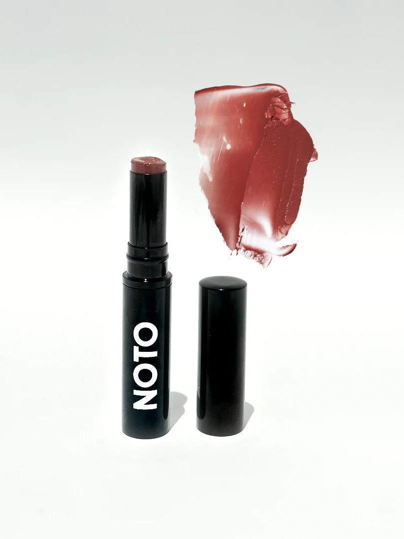 A Five – Multi-Bene Stain Stick // Lips + Cheeks by NOTO with a red color and a black lid.