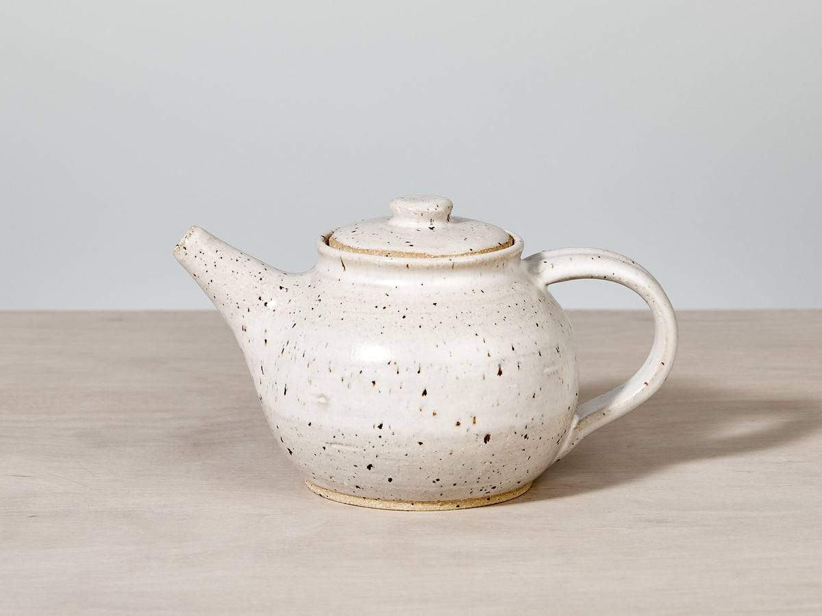 A handmade Tea Pot - Speckled by Nicola Shuttleworth on a wooden table.