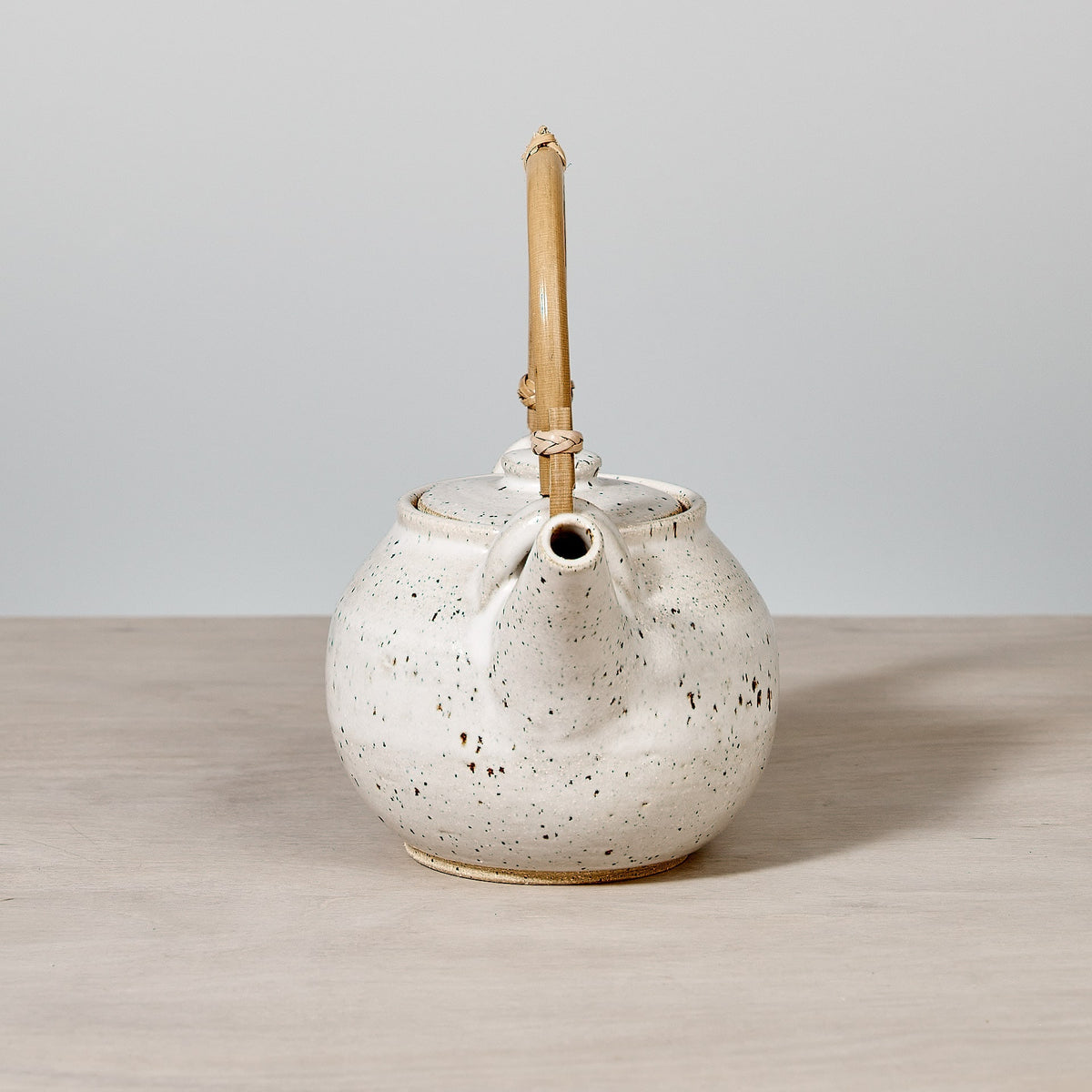A Nicola Shuttleworth tea pot – speckled with bamboo handle – on a wooden table in Wellington.